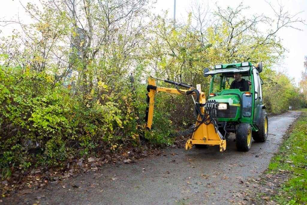 En medarbejder kører en grøn traktor.